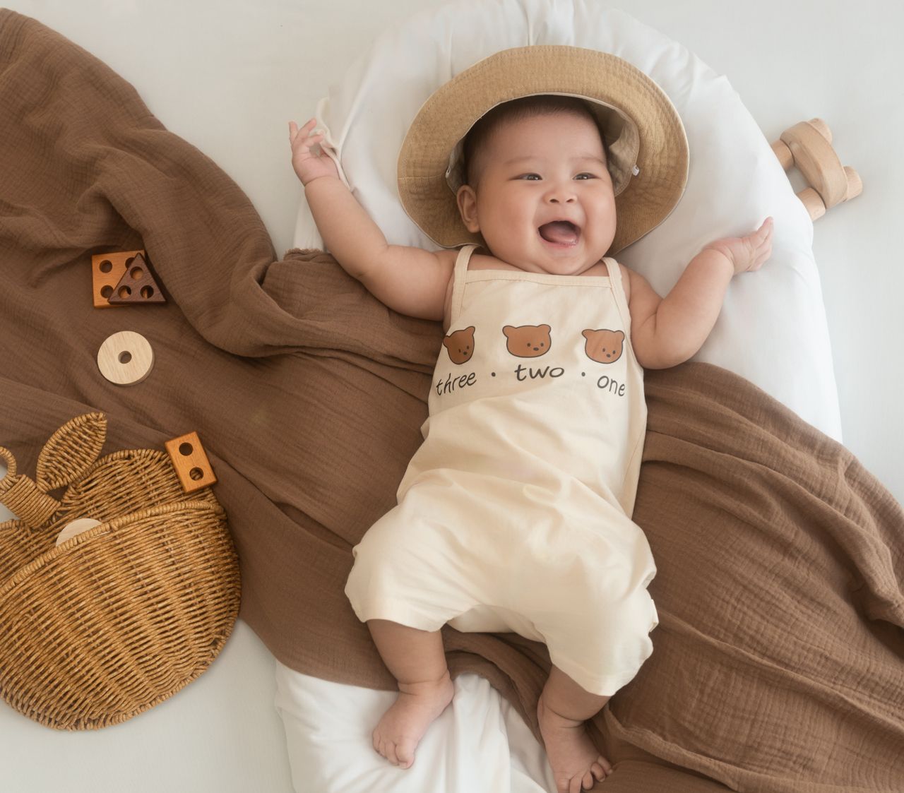 The Art of Drawing Readers In: Your attractive post title goes here Cheerful baby wearing a cute outfit and sun hat lying on cozy bedding.